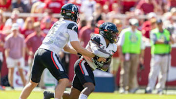 Ben Bryant hands off to Corey Kiner during Cincinnati Bearcats game. Getty Images.
