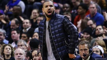 TORONTO, ON - MARCH 06: Rapper Drake shouts from his courtside seat during the second half of an NBA game between the Houston Rockets and the Toronto Raptors at the Air Canada Centre on March 06, 2016 in Toronto, Ontario, Canada. NOTE TO USER: User expressly acknowledges and agrees that, by downloading and or using this photograph, User is consenting to the terms and conditions of the Getty Images License Agreement. (Photo by Vaughn Ridley/Getty Images)