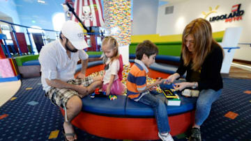 CARLSBAD, CA - SEPTEMBER 17: Tourists from Mexico, Diego, 6, and his sister Ximena, 3, Numata play with Lego toys with their mother Carolina Numata and their uncle Sergio Esqueda in the lobby area of North America's first ever Legoland Hotel at Legoland on September 17, 2013 in Carlsbad, California. The three-story, 250-room hotel is located at the entrance of Legoland California theme park. (Photo by Kevork Djansezian/Getty Images)