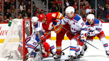 CALGARY, AB - MARCH 15: Garnet Hathaway #21 of the Calgary Flames drives into Alexandar Georgiev #40 the New York Rangers during an NHL game on March 15, 2019 at the Scotiabank Saddledome in Calgary, Alberta, Canada. (Photo by Gerry Thomas/NHLI via Getty Images)