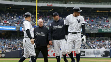 NEW YORK, NEW YORK - APRIL 20: Aaron Judge #99 of the New York Yankees is checked on by bench coach Josh Bard, trainer Steve Donohue and first base coach Reggie Willits #50 prior to leaving a game against the Kansas City Royals in the sixth inning at Yankee Stadium on April 20, 2019 in New York City. (Photo by Jim McIsaac/Getty Images)
