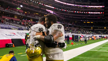 Jan 1, 2021; Arlington, TX, USA; Notre Dame captain Robert Hainsey, left, hugs teammate Aaron Banks on the field following the 2021 College Football Playoff Rose Bowl game on Friday, Jan. 1, 2021, inside AT&T Stadium in Arlington, Texas. Alabama won 31-14. Mandatory Credit: Robert Franklin-USA TODAY Sports