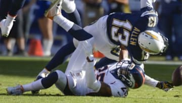 Dec 14, 2014; San Diego, CA, USA; Denver Broncos cornerback Chris Harris (25) brings down San Diego Chargers wide receiver Keenan Allen (13) during second quarter action at Qualcomm Stadium. Mandatory Credit: Robert Hanashiro-USA TODAY Sports