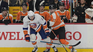 Nov 29, 2022; Philadelphia, Pennsylvania, USA; Philadelphia Flyers center Scott Laughton (21) and New York Islanders defenseman Adam Pelech (3) battle along the boards in the third period at Wells Fargo Center. The Philadelphia Flyers won 3-1. Mandatory Credit: John Geliebter-USA TODAY Sports