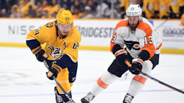 Oct 22, 2022; Nashville, Tennessee, USA; Nashville Predators center Mikael Granlund (64) handles the puck against Philadelphia Flyers center Kevin Hayes (13) during the third period at Bridgestone Arena. Mandatory Credit: Christopher Hanewinckel-USA TODAY Sports