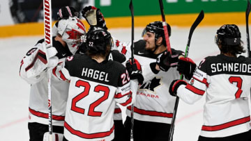 Canada's goalkeeper Darcy Kuemper (L) is celebrated by teammates including New York Rangers prospect Braden Schneider. (Photo by Gints IVUSKANS / AFP) (Photo by GINTS IVUSKANS/AFP via Getty Images)