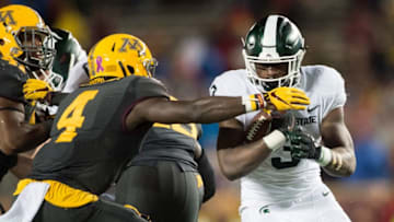 MINNEAPOLIS, MN - OCTOBER 14: LJ Scott #3 of the Michigan State Spartans carries the ball against Adekunle Ayinde #4 of the Minnesota Golden Gophers during the game on October 14, 2017 at TCF Bank Stadium in Minneapolis, Minnesota. The Spartans defeated the Gophers 30-27. (Photo by Hannah Foslien/Getty Images)