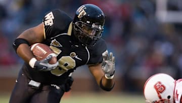 WINSTON-SALEM, NC - NOVEMBER 17: Fullback De'Angelo Bryant (18) of the Wake Forest Demon Deacons tries to avoid DaJuan Morgan (7) of the North Carolina State Wolfpack at BB