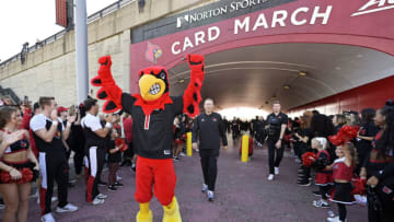 Oct 29, 2022; Louisville, Kentucky, USA; The Louisville Cardinals mascot and head coach Scott Satterfield lead the team to the stadium during the Card March before facing off against the Wake Forest Demon Deacons at Cardinal Stadium. Mandatory Credit: Jamie Rhodes-USA TODAY Sports