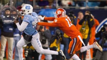 Dec 5, 2015; Charlotte, NC, USA; North Carolina Tar Heels quarterback Marquise Williams (12) carries the ball as Clemson Tigers safety T.J. Green (15) defends during the first quarter in the ACC football championship game at Bank of America Stadium. Mandatory Credit: Jeremy Brevard-USA TODAY Sports