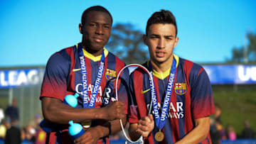 NYON, SWITZERLAND - APRIL 14: NYON, SWITZERLAND - April 14, 2014: Munir El Heddadi (R) and Adama Traore (L) of FC Barcelona celebrate with the Lennart Johansson trophy following victory during the UEFA Youth League Final match between SL Benfica and FC Barcelona at Colovray Stadium on April 14, 2014 in Nyon, Switzerland. (Photo by Paul Murphy - UEFA/UEFA via Getty Images)