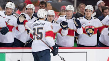 DETROIT, MI - DECEMBER 31: Henrik Borgstrom #95 of the Florida Panthers pounds gloves with teammates on the bench following his second period goal during an NHL game against the Detroit Red Wings at Little Caesars Arena on December 31, 2018 in Detroit, Michigan. (Photo by Dave Reginek/NHLI via Getty Images)