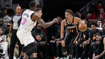 Atlanta Hawks guard Trae Young (11) controls the ball against Miami Heat guard Tyler Herro (14) and center Bam Adebayo (13)(Dale Zanine-USA TODAY Sports)