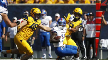 MORGANTOWN, WV - OCTOBER 06: Reese Donahue #46 and Jovanni Stewart #9 of the West Virginia Mountaineers make a tackle behind the line of scrimmage against Steven Sims Jr. #11 of the Kansas Jayhawks in the first quarter of the game at Mountaineer Field on October 6, 2018 in Morgantown, West Virginia. (Photo by Joe Robbins/Getty Images)