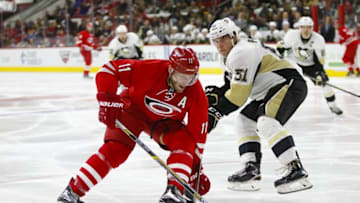 Feb 12, 2016; Raleigh, NC, USA; Carolina Hurricanes forward Jordan Staal (11) skates with the puck past Pittsburgh Penguins defenseman Derek Pouliot (51) during the second period at PNC Arena. Mandatory Credit: James Guillory-USA TODAY Sports