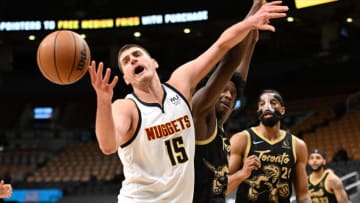 Feb 12, 2022; Toronto, Ontario, CAN; Denver Nuggets center Nikola Jokic (15) reaches a rebound against Toronto Raptors forward OG Anunoby (3) and center Khem Birch (24). Mandatory Credit: Dan Hamilton-USA TODAY Sports
