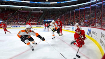 Oct 30, 2016; Raleigh, NC, USA; Carolina Hurricanes defensemen Brett Pesce (22) tries to clear the puck from Philadelphia Flyers forward Travis Konecny (11) during the first period at PNC Arena. Mandatory Credit: James Guillory-USA TODAY Sports