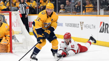 Apr 6, 2023; Nashville, Tennessee, USA; Nashville Predators defenseman Tyson Barrie (22) takes the puck from Carolina Hurricanes center Jesperi Kotkaniemi (82) during the second period at Bridgestone Arena. Mandatory Credit: Christopher Hanewinckel-USA TODAY Sports