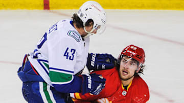 CALGARY, AB - JANUARY 16: Quinn Hughes #43 of the Vancouver Canucks cehcks Andrew Mangiapane #88 of the Calgary Flames during an NHL game at Scotiabank Saddledome on January 16, 2021 in Calgary, Alberta, Canada. (Photo by Derek Leung/Getty Images)