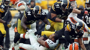 Dec 29, 2013; Pittsburgh, PA, USA; Cleveland Browns running back Edwin Baker (27) has his helmet knocked off as he is hit by Pittsburgh Steelers linebacker Lawrence Timmons (94) , defensive end Cameron Heyward (97) and safety Will Allen (20) in the second half at Heinz Field. The Steelers won the game, 20-7. Mandatory Credit: Jason Bridge-USA TODAY Sports