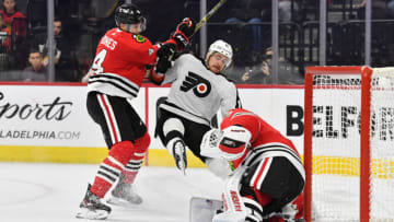 Jan 19, 2023; Philadelphia, Pennsylvania, USA; Philadelphia Flyers right wing Travis Konecny (11) is checked by Chicago Blackhawks defenseman Seth Jones (4) in front of goaltender Petr Mrazek (34) during the third period at Wells Fargo Center. Mandatory Credit: Eric Hartline-USA TODAY Sports