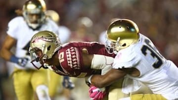 TALLAHASSEE, FL - OCTOBER 18: Travis Rudolph #15 of the Florida State Seminoles is stopped by Cole Luke #36 of the Notre Dame Fighting Irish during their game at Doak Campbell Stadium on October 18, 2014 in Tallahassee, Florida. (Photo by Streeter Lecka/Getty Images)