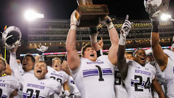 CHAMPAIGN, IL - NOVEMBER 25: Tyler Lancaster #1 of the Northwestern Wildcats hoists the Land of Lincoln Trophy after defeating the Illinois Fighting Illini 42-7 at Memorial Stadium on November 25, 2017 in Champaign, Illinois. (Photo by Michael Hickey/Getty Images)