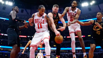 Oct 22, 2022; Chicago, Illinois, USA; Chicago Bulls forward DeMar DeRozan (11) and forward Derrick Jones Jr. (5) go for the ball against Cleveland Cavaliers forward Kevin Love (0) during the second half at United Center. Mandatory Credit: David Banks-USA TODAY Sports