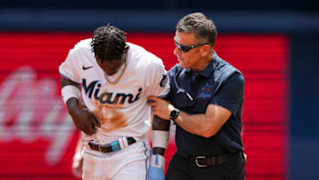 MIAMI, FLORIDA - APRIL 05: Miami Marlins assistant athletic trainer Ben Potenziano tends to Jazz Chisholm Jr. #2 after he is injured attempting to steal second base during the first inning against the Minnesota Twins at loanDepot park on April 05, 2023 in Miami, Florida. (Photo by Eric Espada/Getty Images)