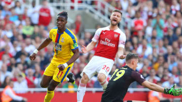 LONDON, ENGLAND - APRIL 21: Wilfried Zaha of Crystal Palace celebrates after scoring his team's second goal whilst Shkodran Mustafi of Arsenal reacts during the Premier League match between Arsenal FC and Crystal Palace at Emirates Stadium on April 21, 2019 in London, United Kingdom. (Photo by Warren Little/Getty Images)