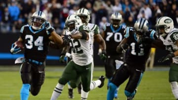 Dec 15, 2013; Charlotte, NC, USA; Carolina Panthers running back DeAngelo Williams (34) scores a touchdown as New York Jets defensive back Aaron Berry (22) and inside linebacker David Harris (52) and cornerback Dee Milliner (27) defend in the second quarter at Bank of America Stadium. Mandatory Credit: Bob Donnan-USA TODAY Sports