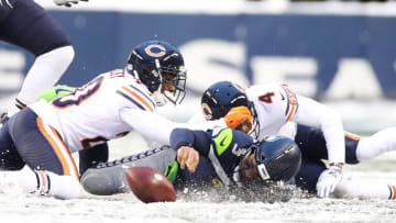 SEATTLE, WASHINGTON - DECEMBER 26: Russell Wilson #3 of the Seattle Seahawks loses the ball as he stretches to gain more yards, but Seattle is able to recover the ball during the second half against the Chicago Bears at Lumen Field on December 26, 2021 in Seattle, Washington. (Photo by Steph Chambers/Getty Images)
