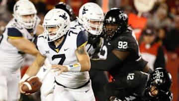 AMES, IA - OCTOBER 13: Quarterback Will Grier #7 of the West Virginia Mountaineers scrambles under pressure from defensive lineman Jamahl Johnson #92 of the Iowa State Cyclones, and defensive back Greg Eisworth #12 of the Iowa State Cyclones in the first half of play at Jack Trice Stadium on October 13, 2018 in Ames, Iowa. The Iowa State Cyclones won 30-14 over the West Virginia Mountaineers. (Photo by David K Purdy/Getty Images)