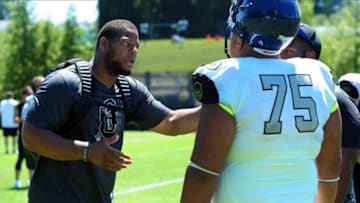 Jul 3, 2013; Beaverton, OR, USA; Detroit Lions player Ndamukong Suh speaks with offensive lineman Damien Mama (75) during the Lineman Challenge session of the 'The Opening' at Nike World Headquarters. Mandatory Credit: Steve Dykes-USA TODAY Sports