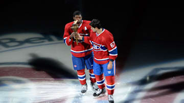 Oct 16, 2014; Montreal, Quebec, CAN; Montreal Canadiens forward Max Pacioretty (67) hands over the torch to teammate P.K. Subban (76) during the introduction ceremony before the game against the Boston Bruins at the Bell Centre. The Canadiens won 6-4. Mandatory Credit: Eric Bolte-USA TODAY Sports