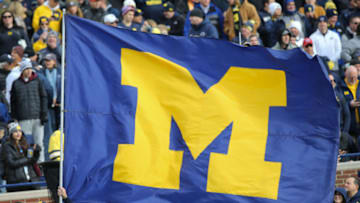 ANN ARBOR, MI - NOVEMBER 03: A Michigan cheerleader runs across the field with the Michigan flag before the start of a game between the Penn State Nittany Lions (14) and the Michigan Wolverines (5) on November 3, 2018 at Michigan Stadium in Ann Arbor, Michigan. (Photo by Scott W. Grau/Icon Sportswire via Getty Images)