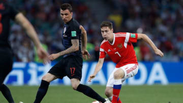 Russia's midfielder Daler Kuzyaev (R) is marked by Croatia's forward Mario Mandzukic. (Photo credit should read ADRIAN DENNIS/AFP via Getty Images)