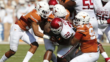 Oct 10, 2015; Dallas, TX, USA; Oklahoma Sooners running back Samaje Perine (32) runs with the ball against Texas Longhorns defensive tackle Hassan Ridgeway (98) Paul Boyette Jr (93) and safety Jason Hall (31) during Red River rivalry at Cotton Bowl Stadium. Mandatory Credit: Matthew Emmons-USA TODAY Sports