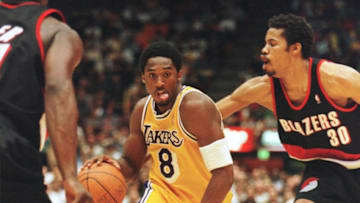 Kobe Bryant of the Los Angeles Lakers (C) drives to the basket past Rasheed Wallace (R) of the Portland Trailblazers during their 24 April playoff game in Los Angeles. Bryant scored 15 points as the Lakers went on to win the game, 104-102 to lead the best of five series, 1-0. AFP PHOTO Vince BUCCI (Photo by VINCE BUCCI / AFP) (Photo by VINCE BUCCI/AFP via Getty Images)