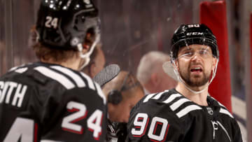 Tomas Tatar #90 of the New Jersey Devils talks with teammate Ty Smith #24 during the first period against the New York Rangers at Prudential Center on March 22, 2022 in Newark, New Jersey. (Photo by Elsa/Getty Images)