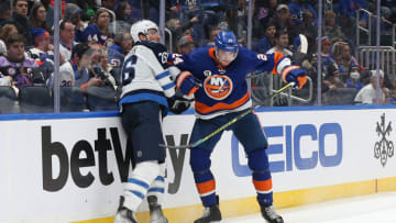 Mar 11, 2022; Elmont, New York, USA; New York Islanders defenseman Scott Mayfield (24) and Winnipeg Jets right wing Blake Wheeler (26) battle for position during the third period at UBS Arena. Mandatory Credit: Andy Marlin-USA TODAY Sports