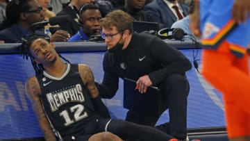 Nov 18, 2022; Memphis, Tennessee, USA; Memphis Grizzlies guard Ja Morant (12) is checked by a staff member after limping off the court during the second half against the Oklahoma City Thunder at FedExForum. Mandatory Credit: Petre Thomas-USA TODAY Sports