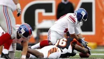 Nov 11, 2012; Cincinnati, OH, USA; Cincinnati Bengals defensive end Carlos Dunlap (96) and the New York Giants tight end Travis Beckum (47) go for a fumble during the second half at Paul Brown Stadium. The Bengals defeated the Giants 31-13. Mandatory Credit: Frank Victores-USA TODAY Sports