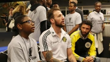Dec 3, 2015; Columbus, OH, USA; Columbus Crew goalkeeper Steve Clark plays video games with a boy from the Boys and Girls Club at the Milo-Grogan Boys and Girls Club. Mandatory Credit: Aaron Doster-USA TODAY Sports
