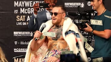 NEW YORK, NY - JULY 13: Conor McGregor looks on as money rains down during the Floyd Mayweather Jr. v Conor McGregor World Press Tour event at Barclays Center on July 13, 2017 in the Brooklyn borough of New York City. (Photo by Mike Lawrie/Getty Images)