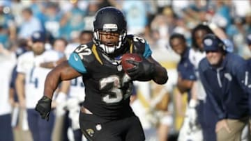 Dec 22, 2013; Jacksonville, FL, USA; Jacksonville Jaguars running back Maurice Jones-Drew (32) runs with the ball as Tennessee Titans defends during the second half at EverBank Field. Tennessee Titans defeated the Jacksonville Jaguars 20-16. Mandatory Credit: Kim Klement-USA TODAY Sports