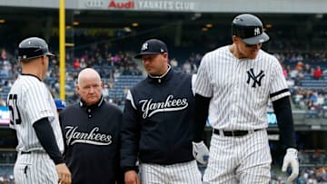 NEW YORK, NEW YORK - APRIL 20: Aaron Judge #99 of the New York Yankees is checked on by bench coach Josh Bard, trainer Steve Donohue and first base coach Reggie Willits #50 prior to leaving a game against the Kansas City Royals in the sixth inning at Yankee Stadium on April 20, 2019 in New York City. (Photo by Jim McIsaac/Getty Images)
