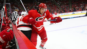 Jan 3, 2017; Raleigh, NC, USA; Carolina Hurricanes forward Victor Rask (49) checks New Jersey Devils forward Miles Wood (44) into the boards during the first period at PNC Arena. Mandatory Credit: James Guillory-USA TODAY Sports
