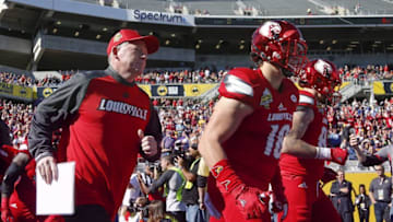Dec 31, 2016; Orlando, FL, USA; Louisville Cardinals head coach Bobby Petrino (left) runs onto the field with tight end Cole Hikutini (18) and quarterback Lamar Jackson (8) before an NCAA football game against the LSU Tigers in the Buffalo Wild Wings Citrus Bowl at Camping World Stadium. Mandatory Credit: Reinhold Matay-USA TODAY Sports