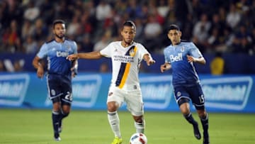August 27, 2016; Carson, CA, USA; Los Angeles Galaxy forward Giovani dos Santos (10) moves the ball against Vancouver Whitecaps FC midfielder Matias Laba (15) and midfielder Giles Barnes (28) during the second half at StubHub Center. Mandatory Credit: Gary A. Vasquez-USA TODAY Sports
